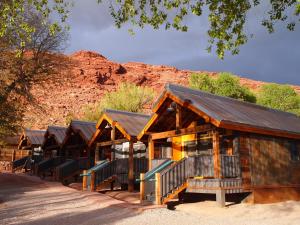 a row of wooden cabins with a mountain in the background at Moab Springs Ranch in Moab