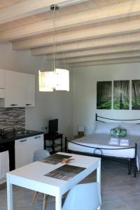Habitación con cama, mesa y cocina. en Paradeisos Residence Sas, en Somma Lombardo