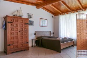 a bedroom with a bed and a wooden cabinet and a window at Casa Lupita - Private Family Villa with Pool & Garden in Terracina +35 photos