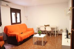 a living room with an orange couch and a table at Apartamentos nueva 13 in Ronda