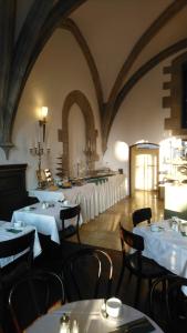 un comedor con mesas y sillas con mantel blanco en Hotel Kaiserhof am Dom, en Regensburg