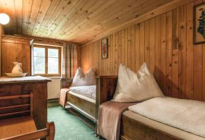 ヴァルト・アム・アールベルクにあるHaus Ganahl Klostertalの木造キャビン内のベッドルーム1室(ベッド2台付)