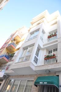 un bâtiment blanc avec des fleurs sur les fenêtres dans l'établissement Deka Evleri, à Izmir