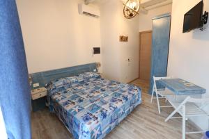 a bedroom with a bed and a table and a desk at ANTICA DIMORA DELL'AMMIRAGLIO in Licata