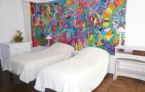 サン・ジェルヴェ・ラ・フォレにあるGîte de Charme 5 pers.の壁に絵画が飾られた部屋のベッド2台