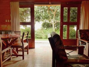 a dining room with a table and chairs and a window at Rancho Amalia Lodge in Naranjo