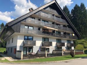 a large white building with wooden balconies at Apartma Vintage Bohinj in Bohinj