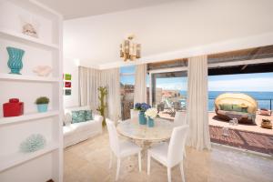 ein Wohnzimmer mit einem Tisch und Meerblick in der Unterkunft Boutique Penthouse by AMALFIVACATION in Minori
