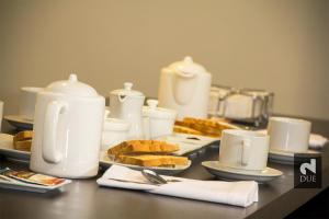 a table topped with plates of food and white appliances at Due in Trujillo