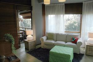 un soggiorno con divano bianco e finestra di Prestigioso appartamento Lagomare a Torre del Lago Puccini