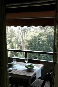 un tavolo con bicchieri da vino seduti di fronte a una finestra di Prestigioso appartamento Lagomare a Torre del Lago Puccini
