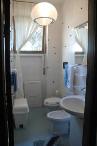 bagno con lavandino, servizi igienici e finestra di Prestigioso appartamento Lagomare a Torre del Lago Puccini