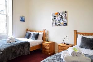 a bedroom with two beds and a window at ALTIDO Castle Terrace 3 bedroom Apartment - Old Town in Edinburgh