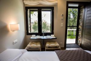 a bedroom with two beds and a table and two windows at Centro Medioambiental The Nest - Adults Only - Digital Detox in El Plano