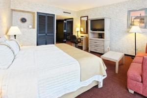 Pokój hotelowy z dużym białym łóżkiem i krzesłem w obiekcie Holiday Inn Monterrey-Parque Fundidora, an IHG Hotel w mieście Monterrey