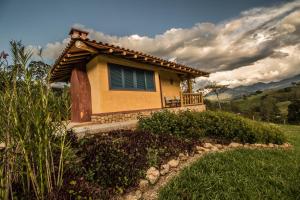 a small house on top of a grass field at Pousada Maria Manhã in Passa Quatro