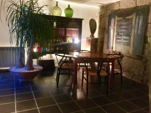 uma sala de jantar com mesa e cadeiras e uma planta em Casal do Arcebispado em Felgueiras