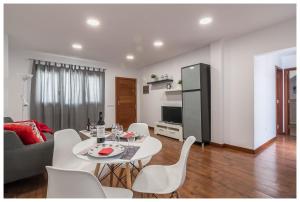 een woonkamer met een witte tafel en witte stoelen bij La Casita del Centro in Vega de San Mateo