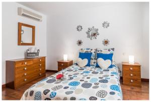 een slaapkamer met een bed met blauwe en witte kussens bij La Casita del Centro in Vega de San Mateo
