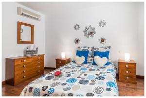 a bedroom with a bed with blue and white pillows at La Casita del Centro in Vega de San Mateo