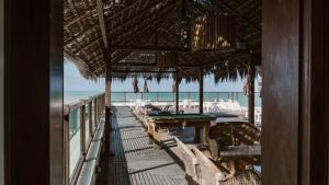 un restaurante con mesas y sillas en la playa en Araçá Flat 106, en Natal
