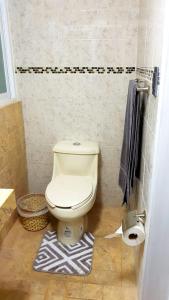 a bathroom with a toilet and a rug on the floor at Departamento Privado 3 recamaras in Mexico City