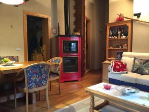- un salon avec une table et un poêle rouge dans l'établissement Appartamento Les Jumeaux, à Breuil-Cervinia