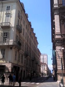 都靈的住宿－Alloggio Fronte Egizio，一群人沿着建筑物旁边的街道走着