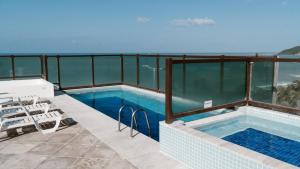 una piscina en un balcón con vistas al océano en Araçá Flat 106, en Natal