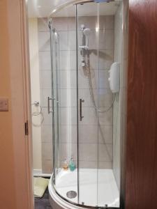 La salle de bains est pourvue d'une douche avec une porte en verre. dans l'établissement Robinhill Garden, à Forres