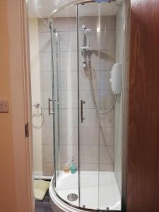 a shower with a glass door in a bathroom at Robinhill Garden in Forres