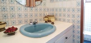 a bathroom with a blue sink and a mirror at Chester´s B&B in Tababela