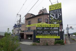 un panneau devant un bâtiment comportant des panneaux dans l'établissement スタンドアップ法隆寺Adult Only男塾ホテルグループ, à Yamatokoriyama