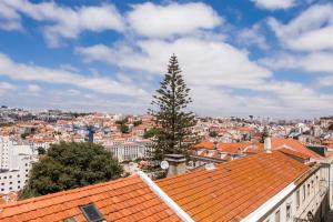 a view of a city with a tree on the roofs at Breath-Taking River & City View Stunning 3 Bedrooms & 3 Bathrooms With AC Alfama Castle district 1st Floor Apartment in Lisbon