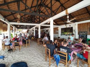 a group of people sitting in chairs at a restaurant at Evolution Dive and Beach Resort in Malapascua Island