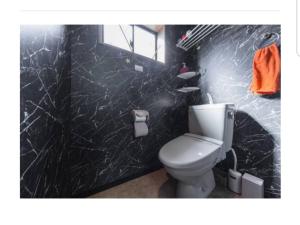 a bathroom with a white toilet and a black wall at Kiyamachi Guesthouse in Kyoto