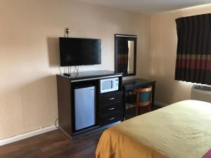 a hotel room with a bed and a flat screen tv at Manhattan Inn & Suites in Manhattan Beach