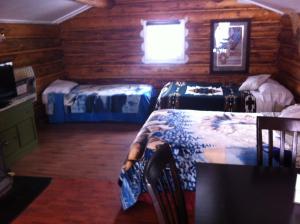 a room with two beds in a log cabin at Tetsa River Lodge in Tetsa River