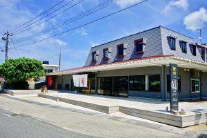een gebouw aan de kant van een straat bij Denpaku Akakina Hotel in Amami