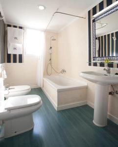 ein Badezimmer mit einem WC, einer Badewanne und einem Waschbecken in der Unterkunft HRC Hotel in Madrid