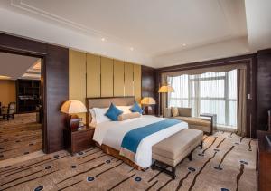 a large bedroom with a large bed and a couch at Expo Center Hotel in Yiwu