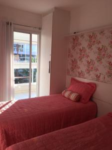 a bedroom with two beds and a window at Apartamento na Riviera de Sao Lourenco in Riviera de São Lourenço