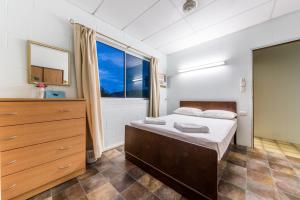 a bedroom with a bed and a large window at Birdsong House- Dingo Beach in Hideaway Bay