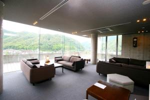 a lobby with couches and chairs and a large window at Hotel Seira Shimanto in Shimanto
