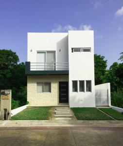 Casa blanca con balcón en la parte superior. en Hermosa Casa Vacacional Puerto Morelos en Puerto Morelos