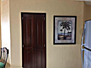 a door in a room with a picture of a palm tree at Sonoran Sea Resort in Puerto Peñasco