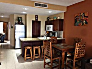 a kitchen with a table and chairs and a refrigerator at Sonoran Sea Resort in Puerto Peñasco