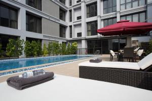 una piscina de hotel con mesa y sombrilla en South Urban Hotel, en Chiayi