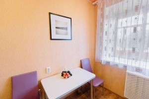 トムスクにあるАпартаменты Елизаровых 10のダイニングルーム(白いテーブル、紫色の椅子付)
