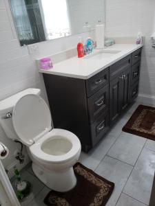 a bathroom with a white toilet and a sink at Comfortable holiday homestay in Bronx